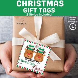 May include: A wrapped gift with a cream-colored ribbon and a Christmas gift tag. The tag features reindeer illustrations with coffee cups and the text "Wishing You A Warm & Cozy Christmas". The top of the image reads "CHRISTMAS GIFT TAGS".