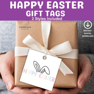 Könnte beinhalten: Ein Geschenk, das mit einem weißen Band und einem quadratischen Geschenkanhänger verpackt ist. Der Anhänger hat ein Hasenohren-Design und die Worte "HAPPY EASTER" in Pastellfarben. Das Bild enthält auch den Text "GIFT TAGS" und "2 Styles Included".