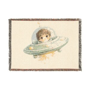 Schattig kindje in een geweven deken in de vorm van een UFO | Ruimteschipdeken