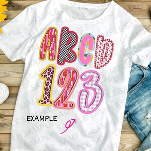May include: White t-shirt featuring the letters "ABCD" and numbers "123" in vibrant patterns. Designs include leopard print, hearts, and a checkered pattern. The word "EXAMPLE" is printed below the numbers, showcasing a playful design.