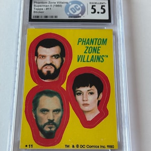 May include: A graded Phantom Zone Villains sticker from Superman II (1980) by Topps. The yellow sticker features three villain portraits in red outlines, with the text "Phantom Zone Villains" and the number "11". The sticker is encased in a protective holder.