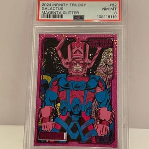 May include: A magenta glitter trading card featuring a comic book illustration of Galactus from the 2024 Infinity Trilogy series. The card is encased in a protective plastic holder with a label that includes the card's name, series, and grading information.