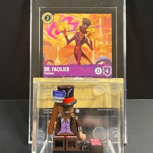 May include: A LEGO minifigure of Dr. Facilier from Disney's The Princess and the Frog. The minifigure is wearing a purple vest, brown pants, and a black top hat with a red band. He is holding a cane with a blue and white top. The minifigure is displayed in a clear plastic case with a card featuring an illustration of Dr. Facilier.