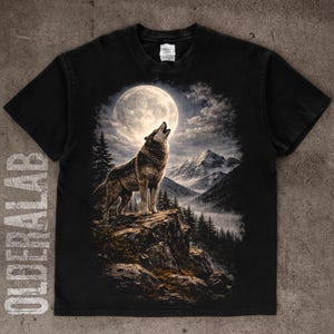 May include: Black t-shirt featuring a detailed illustration of a wolf howling at a full moon. The design includes a mountain range, pine trees, and a cloudy sky. The text "OLDERLAB" is printed vertically on the left side of the shirt.