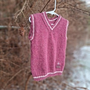 Soft pink vest is a handmade creation. Crafted with high-quality, soft, and cozy yarn. The vest is adorned with delicate embroidery.