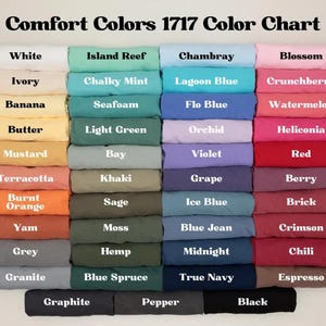 May include: A color chart displaying a variety of Comfort Colors 1717 fabric swatches. The chart features a range of colors, including white, ivory, banana, butter, mustard, terracotta, burnt orange, yam, grey, granite, island reef, chalky mint, seafoam, light green, bay, khaki, sage, moss, hemp, blue spruce, chambray, lagoon blue, flo blue, orchid, violet, grape, ice blue, blue jean, midnight, true navy, blossom, crunchberry, watermelon, heliconia, red, berry, brick, crimson, chili, espresso, graphite, pepper, and black.