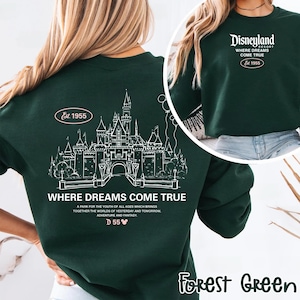 May include: Forest green sweatshirt with a white graphic of a castle and the text "WHERE DREAMS COME TRUE". The sweatshirt also features the text "Disneyland Resort Where Dreams Come True Est. 1955".