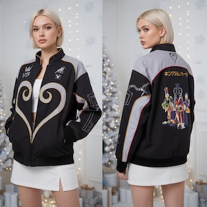 Peut inclure: Veste zippée noire avec le haut du dos et les manches grises. L'avant présente un grand motif de cœur avec des bordures dorées et du texte japonais. Le dos comporte un graphisme coloré de personnages de dessins animés et du texte japonais. La veste a un col montant.