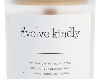 Puede incluir: Un tarro de vela de vidrio esmerilado con tapa de madera. La etiqueta dice "Evolve kindly" y enumera las características de la vela: blanco natural, cera de soja de coco mezclada y vertida a mano en EE. UU. Un artículo de decoración neutro.