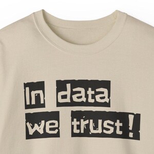 Peut inclure: Un sweat-shirt beige avec un texte noir qui dit "In data we trust!" Le texte est en gras et en caractères d'imprimerie.