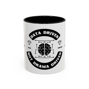 Peut inclure: Une tasse à café en céramique blanche avec un bord noir et un motif graphique noir et blanc. Le graphique représente un cerveau avec des lignes de circuit imprimé et le texte "Data Driven Not Drama Driven".