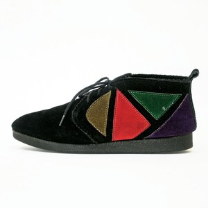 May include: Black suede ankle boots with colorful geometric patches in red, green, purple, and brown.
