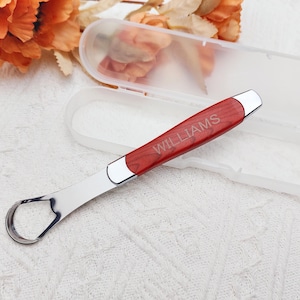 May include: A personalized red and silver bottle opener with the name "WILLIAMS" engraved on the handle. The opener comes with a clear plastic case.