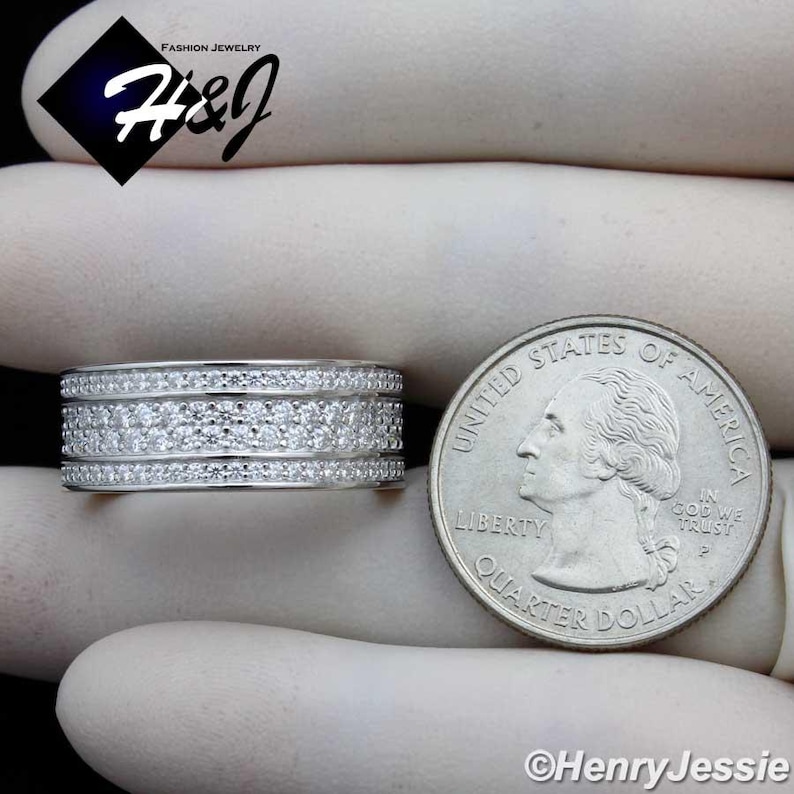 May include: A silver ring with multiple rows of small, clear stones. The ring is next to a US quarter coin for size comparison. The image includes the text "FASHION JEWELRY H&J" and "&copy;Henry Jessie".