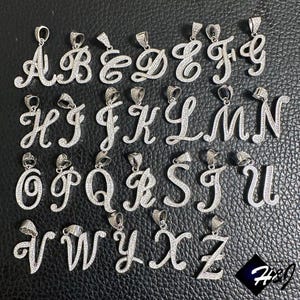 May include: A set of 26 silver pendants, each featuring a different letter of the alphabet in a cursive script. The pendants are adorned with clear cubic zirconia stones.