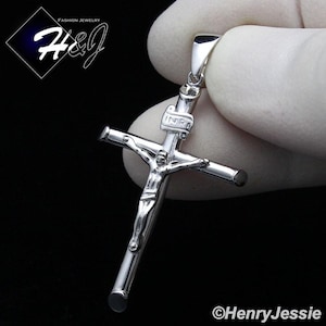 May include: Silver crucifix pendant with a detailed figure of Jesus Christ. The pendant features the inscription "INRI" on the cross.