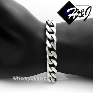May include: A silver curb chain bracelet with a polished finish. The bracelet is made of stainless steel and has a secure clasp.