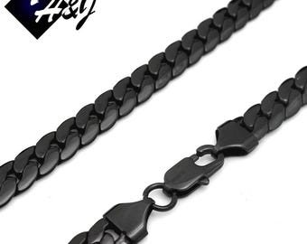 Puede incluir: Un collar de cadena curb negro con cierre de mosquetón. La cadena es de metal y tiene un acabado brillante.