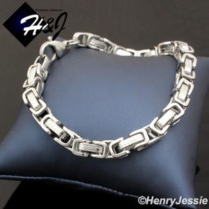 May include: A silver chain bracelet with a box chain design. The chain is made of stainless steel and has a polished finish.