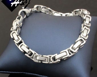May include: A silver chain bracelet with a box chain design. The chain is made of stainless steel and has a polished finish.