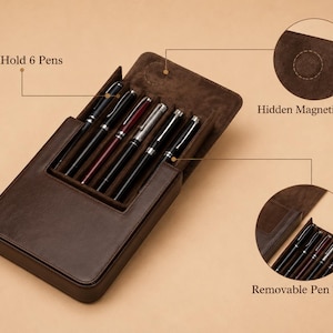 Pode incluir: Um estojo de caneta de couro marrom com seis canetas dentro. O estojo tem um fecho magn&eacute;tico oculto e uma bandeja de caneta remov&iacute;vel. O texto "Can Hold 6 Pens" &eacute; vis&iacute;vel. As canetas s&atilde;o pretas, prateadas e bord&ocirc;.