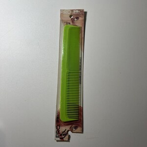 May include: A neon green comb in its original packaging. The comb is made of plastic and has fine teeth. The packaging has the text "PRO 39" and "GUARANTEED UNBREAKABLE".