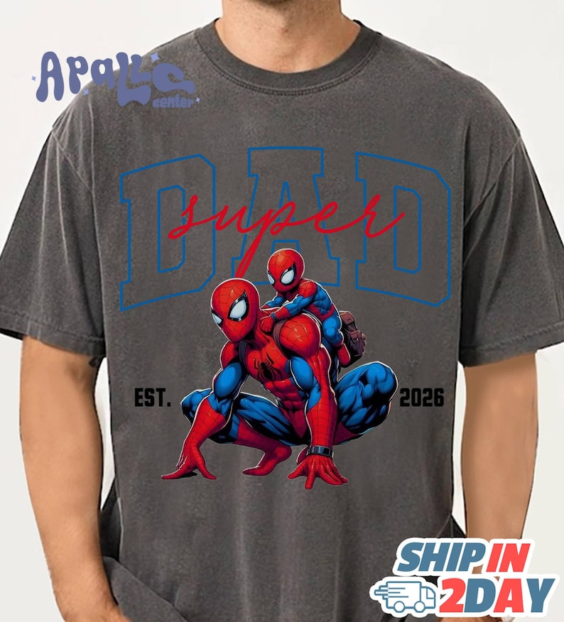 A gray t-shirt with a graphic design featuring two Spider-Man characters, one larger and one smaller, with the text "SUPER DAD" and "EST. 2026" printed on it.