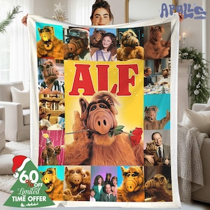 May include: A white blanket featuring a collage of images of the character ALF, with the word "ALF" in large red letters. The blanket has a variety of images of ALF and the cast.