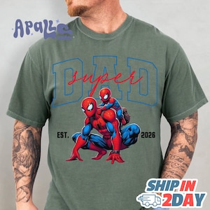 A man wearing a green t-shirt with a graphic of Spider-Man and the text "SUPER DAD" printed on it.