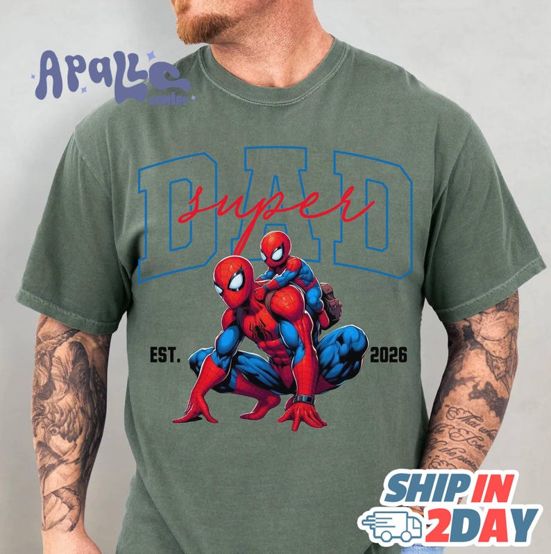 A man wearing a green t-shirt with a graphic of Spider-Man and the text "SUPER DAD" printed on it.