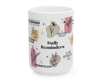 May include: White ceramic mug with a floral design and inspirational quotes. The quotes include "Have courage to set boundaries and don't be sorry", "Good things take time", "I choose peace", "Daily Reminders", "I deserve joy", and "I am strong AF".