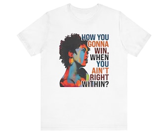 Op de afbeelding: Wit T-shirt met een kleurrijk portret van een vrouw en de tekst "HOW YOU GONNA WIN, WHEN YOU AIN'T RIGHT WITHIN?" in blauw, oranje en geel. Het ontwerp heeft een levendige, artistieke stijl.