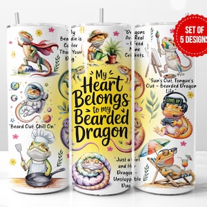May include: A set of five white 20 oz. insulated tumblers featuring colorful cartoon bearded dragons in various scenarios. Each tumbler has a different design, including text like "My Heart Belongs to my Bearded Dragon."