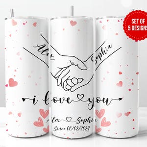 May include: Set of three white stainless steel tumblers with pink hearts and a black outline of two hands holding each other. The tumblers are personalised with the names "Alex" and "Sophia" and the text "I love you" and "Since 06/02/2024".
