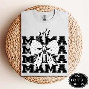 May include: A gray t-shirt with a black and white design. The design features the text "golf mama" repeated four times with a white golf ball bow in the center.