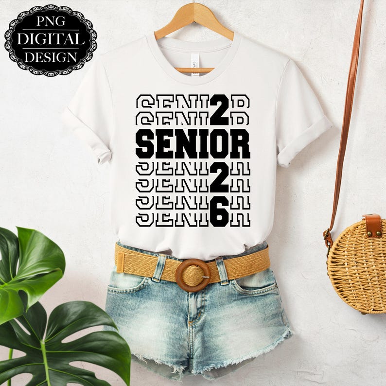 Pu&ograve; includere: Maglietta bianca con testo nero che ripete pi&ugrave; volte "Senior 22". La maglietta &egrave; indossata sopra un paio di pantaloncini di jeans blu chiaro e una cintura marrone.