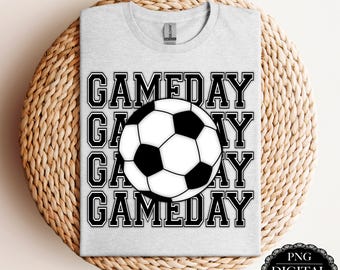 May include: A gray t-shirt with the text "GAMEDAY" repeated four times in black. A black and white soccer ball is centered in the middle of the text.
