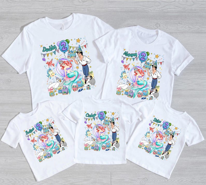 Peut inclure: Cinq t-shirts blancs &agrave; manches courtes avec un motif color&eacute; repr&eacute;sentant une sir&egrave;ne, un prince et des cr&eacute;atures marines c&eacute;l&eacute;brant un deuxi&egrave;me anniversaire. Chaque t-shirt porte le texte Daddy, Mommy, Brother, Sister ou Birthday Girl avec un deux.