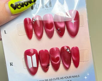 Faux ongles à coller inspirés des ARMY, avec un cœur rouge et des yeux de chat, et des motifs blancs inspirés par le style « cœur ARMY » : créations de fans. Prêts à être expédiés.