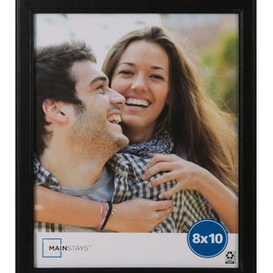 May include: A black rectangular picture frame with a photograph of a smiling couple. The frame is labeled "Mainstays" and the photo size is 8x10 inches.