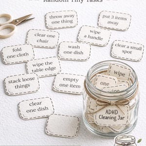 Può includere: Un barattolo per la pulizia dell'ADHD con "Random Tiny Tasks" scritto in alto. Il barattolo è pieno di piccole schede attività, come "buttare via una cosa" e "pulire una maniglia". A sinistra ci sono un paio di forbici.