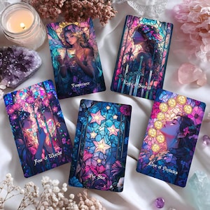 Puede incluir: Una colección de cartas del tarot con ilustraciones coloridas. Las cartas presentan imágenes de mujeres, estrellas y diseños florales. Las cartas están etiquetadas con títulos como "Templanza", "Ocho de Espadas" y "La Estrella."