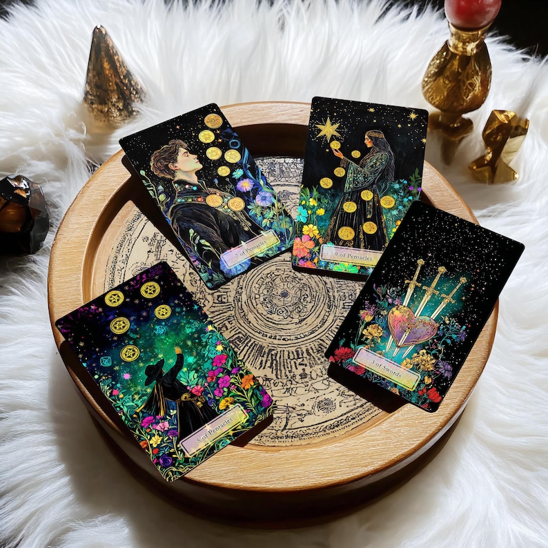 May include: Four tarot cards on a wooden tray with a circular design. The cards are from the 'Mystic Mondays' deck and feature illustrations of people and symbols. The cards are: 5 of Pentacles, 8 of Pentacles, 3 of Swords, and 6 of Pentacles.