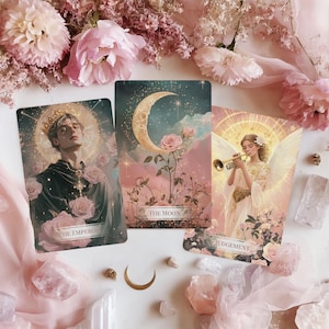 Pode incluir: Três cartas de tarô com imagens florais e celestiais. As cartas apresentam ilustrações de uma figura coroada, uma lua crescente com rosas e um anjo tocando trompete. As cartas são cercadas por flores cor-de-rosa e cristais.