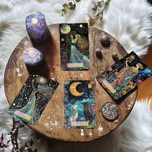 May include: Four tarot cards on a wooden table with candles and stones. The cards are "The Lovers", "The World", "The Moon", and "Justice".