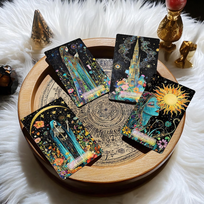 May include: Five tarot cards on a wooden tray with a black background and colourful floral designs. The cards are "The High Priestess", "The Tower", "The Sun", "Death", and "The World".