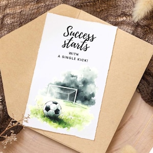 May include: A watercolor illustration of a soccer ball on a green field with a goal in the background. The text "Success starts with a single kick!" is written above the image.