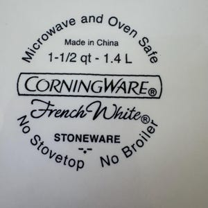 May include: White stoneware dish with the text "CORNINGWARE French White". The dish is microwave and oven safe, with a capacity of 1-1/2 qt - 1.4 L. It is not stovetop or broiler safe. Made in China.