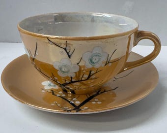 Tazza da tè vintage giapponese con piattino a forma di fiore di ciliegio, dipinta a mano, realizzata in Giappone con finitura lucida color pesca e oro.