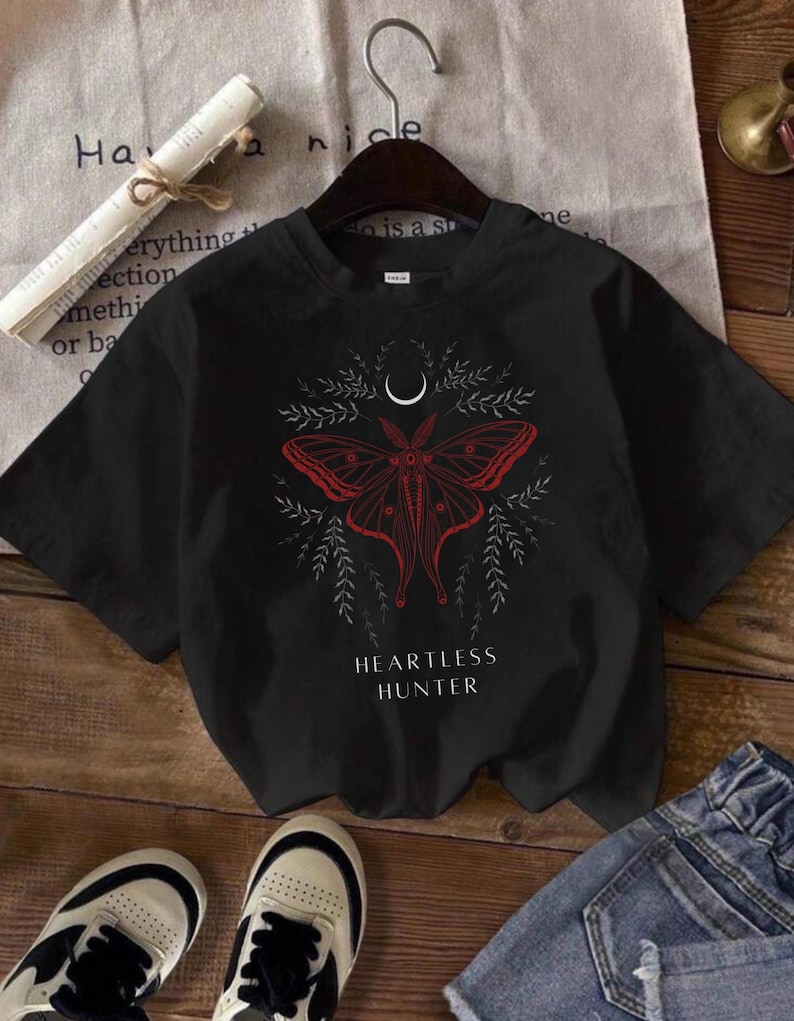 May include: Black t-shirt with a red and white moth graphic and the text "Heartless Hunter".